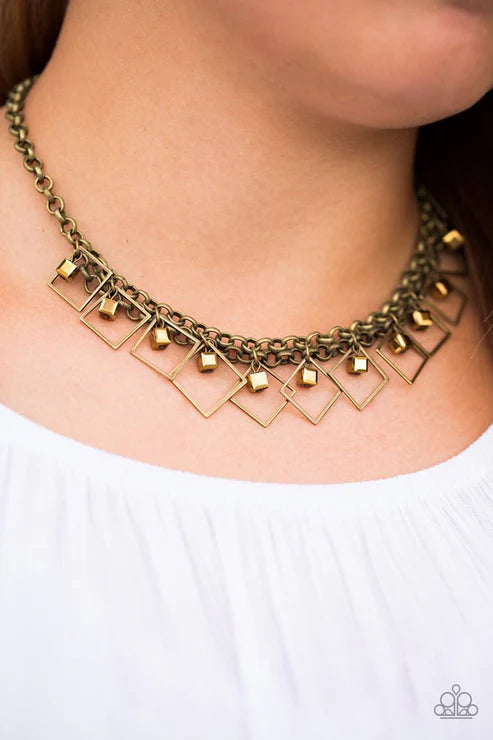 Necklace with geometric pendants on a person wearing a white top
