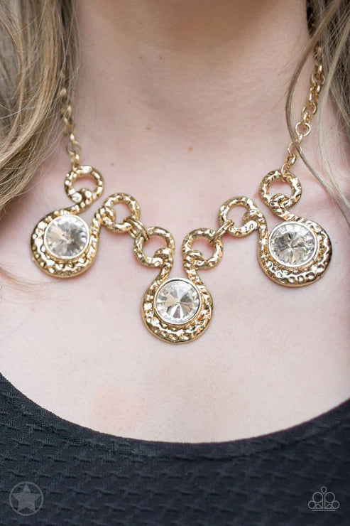 Gold necklace with circular pendants on a person wearing a black top.
