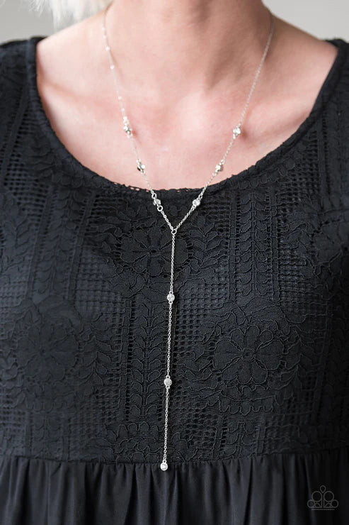 Silver necklace on a person wearing a black lace top