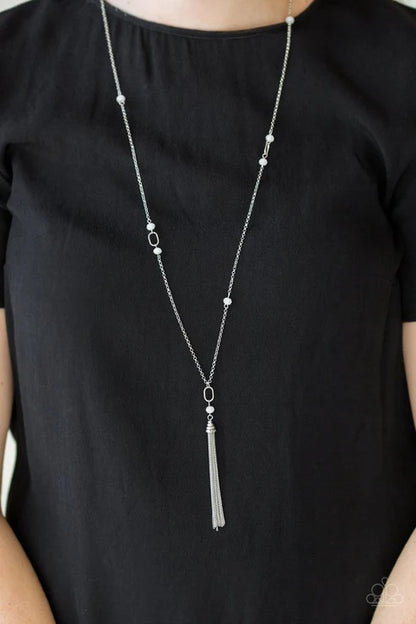 Silver necklace with a tassel on a black shirt