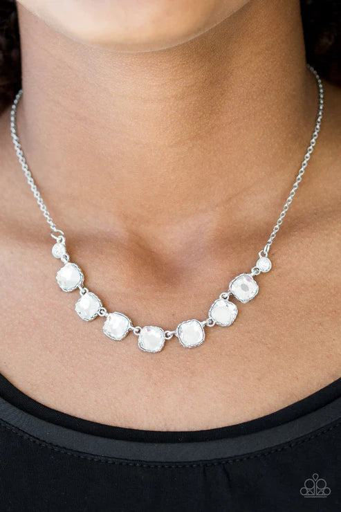 Silver necklace with round pendants on a person wearing a black top.