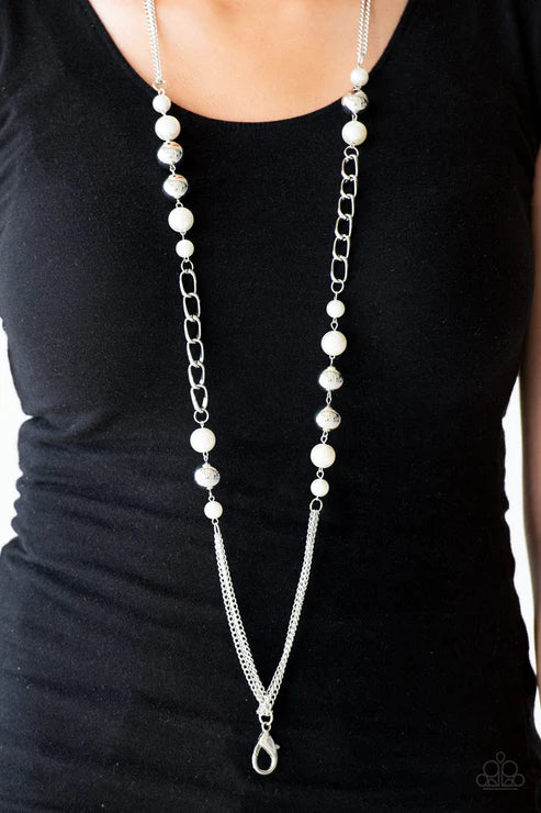 Silver chain and pearl necklace on a black background