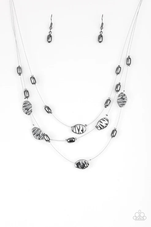 Necklace and earrings set with silver and black beads on a white background