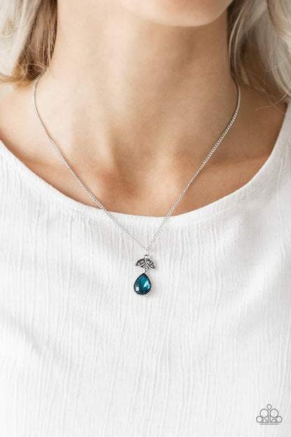 Necklace with a blue teardrop pendant worn by a person on a white background