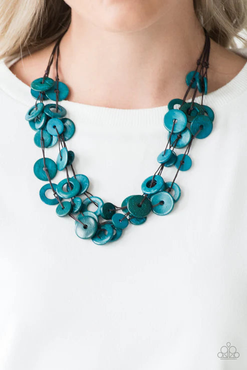 Teal button necklace worn by a person on a white background