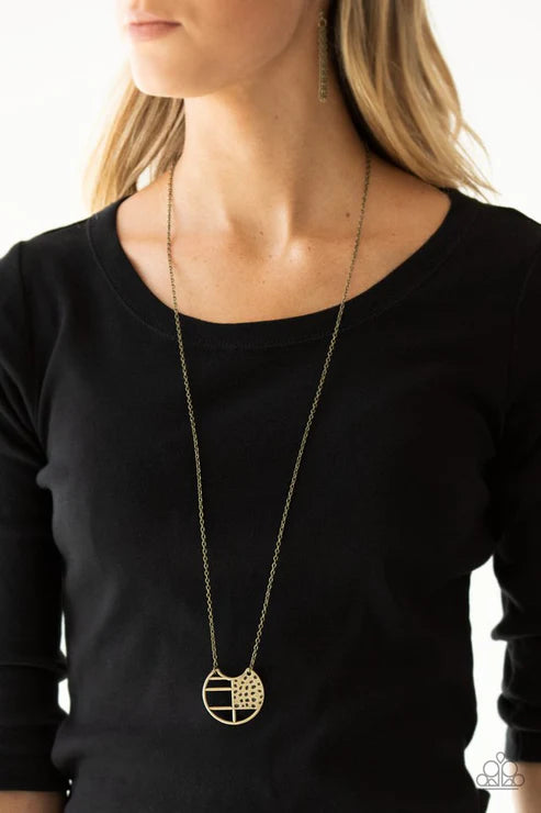 Gold necklace worn by a person against a plain background