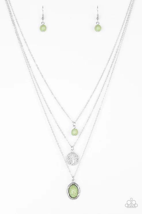 Necklace set with green pendant and matching earrings on a white background