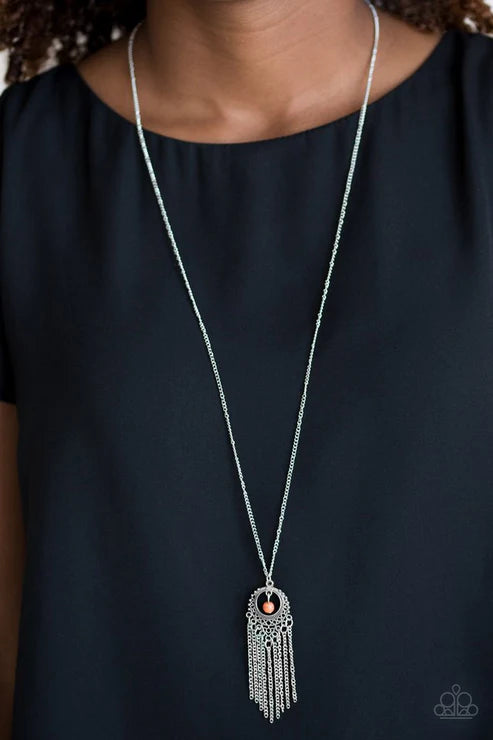 Long silver necklace with a pendant on a black background