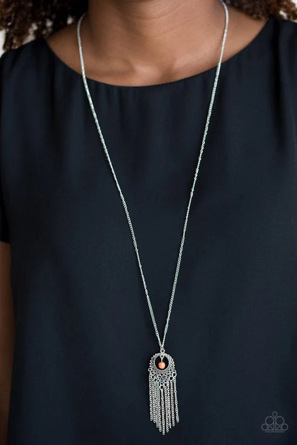 Long silver necklace with a pendant on a black background