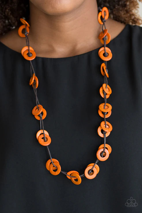 Necklace with orange and black circular links on a plain background