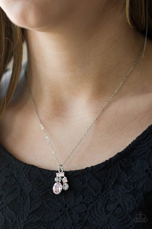 Necklace with a pendant worn by a person against a black background