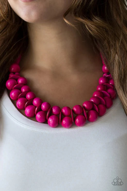 Close-up of a bright pink beaded necklace on a white background