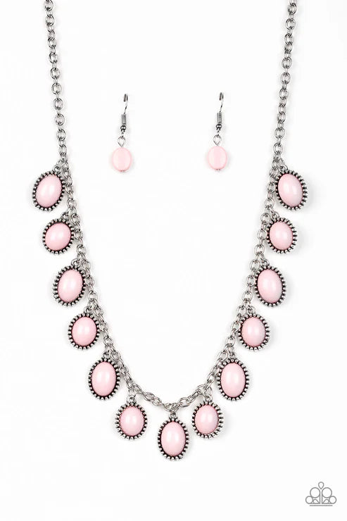 Necklace and earrings set with pink stones on a white background