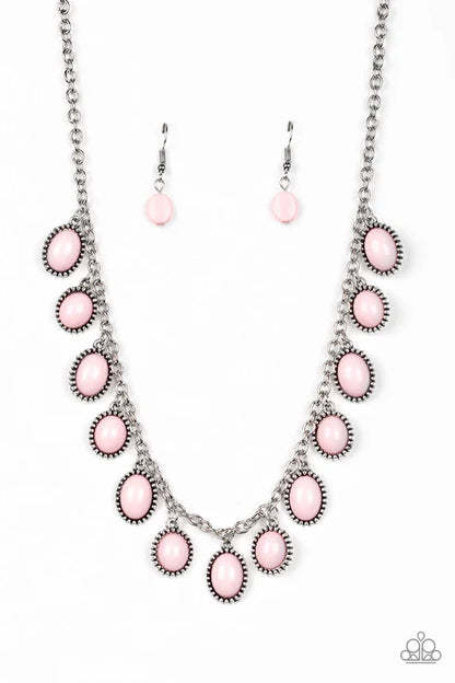 Necklace and earrings set with pink stones on a white background