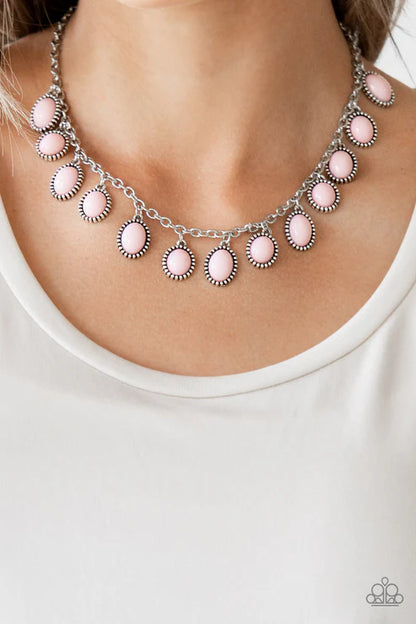 Necklace with pink and silver circular pendants on a white background