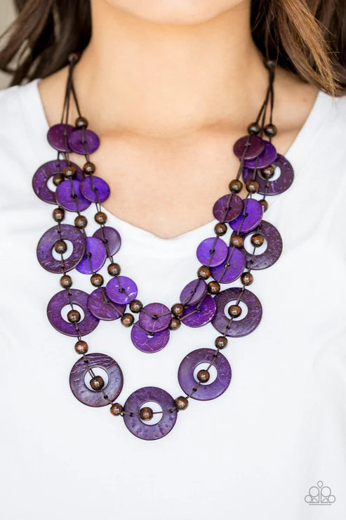 Purple and brown beaded necklace worn by a person on a white background