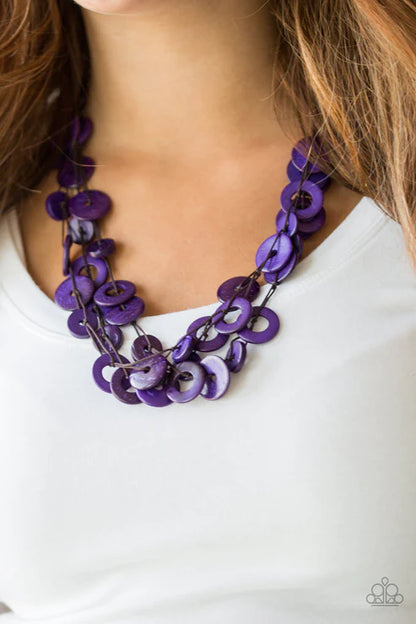 Purple necklace worn by a person on a white background