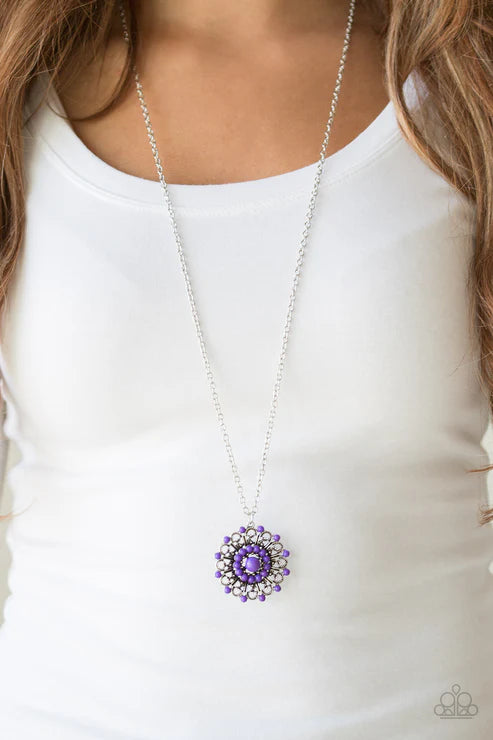 Purple pendant necklace on a white shirt