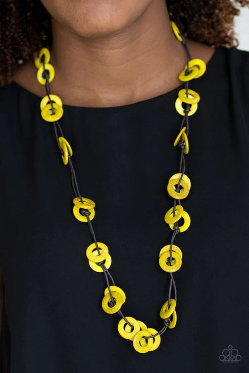 Yellow and black necklace on a person wearing a black top