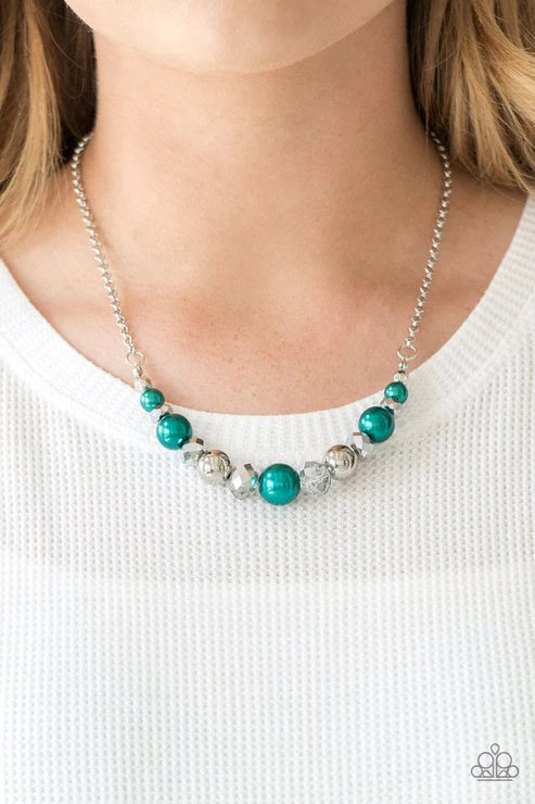 Necklace with turquoise and silver beads worn by a person on a white background