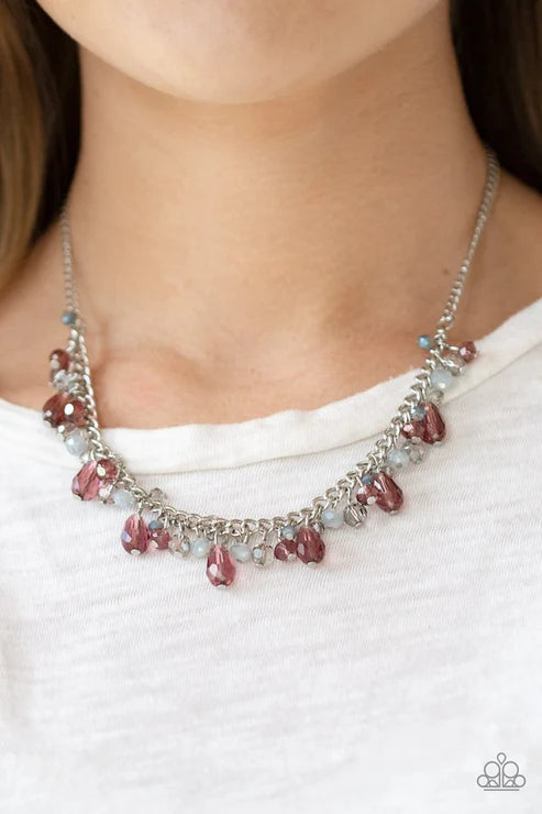 Necklace with pink and clear beads worn by a person on a white background