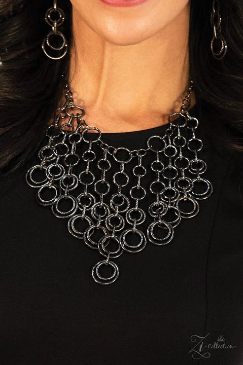 Close-up of a person wearing a black chain necklace with a blurred background