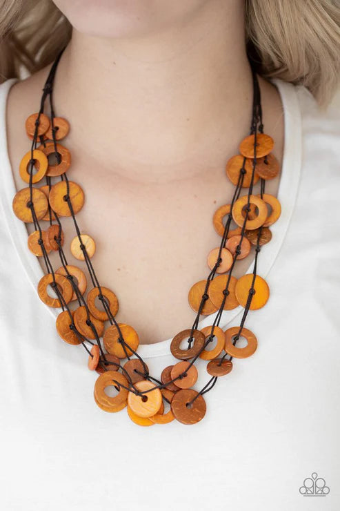 Necklace with orange circular beads and black strings on a white background