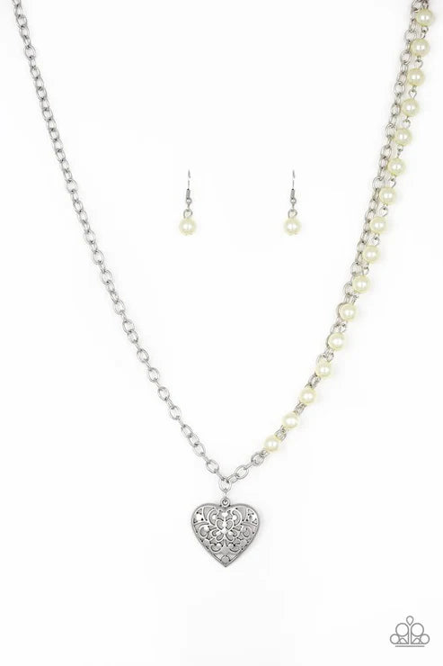 Pearl necklace with silver heart pendant and matching earrings on a white background