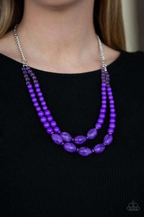 Purple beaded necklace on a black background