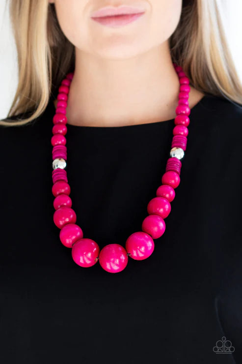 Necklace with bright pink beads on a plain background