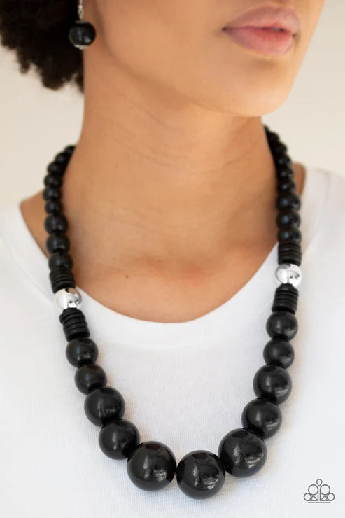 Black beaded necklace with silver accents worn by a person on a white background