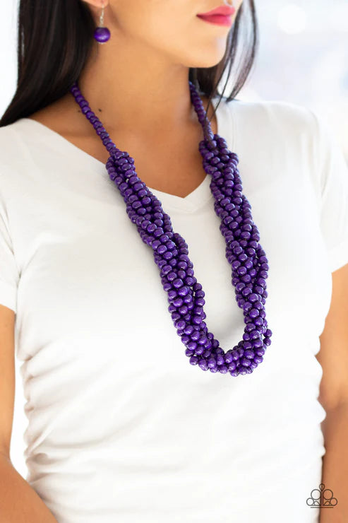 Purple beaded necklace worn by a person on a white background