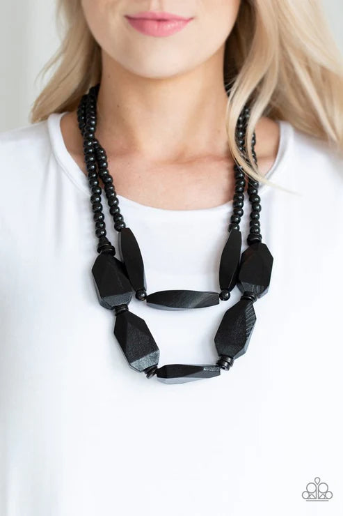 Black beaded necklace worn by a person on a white background