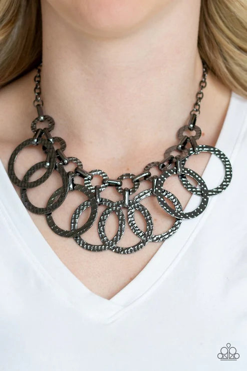 Necklace with interlocking rings worn by a person on a white background