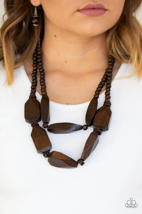 Brown beaded necklace worn by a person on a white background