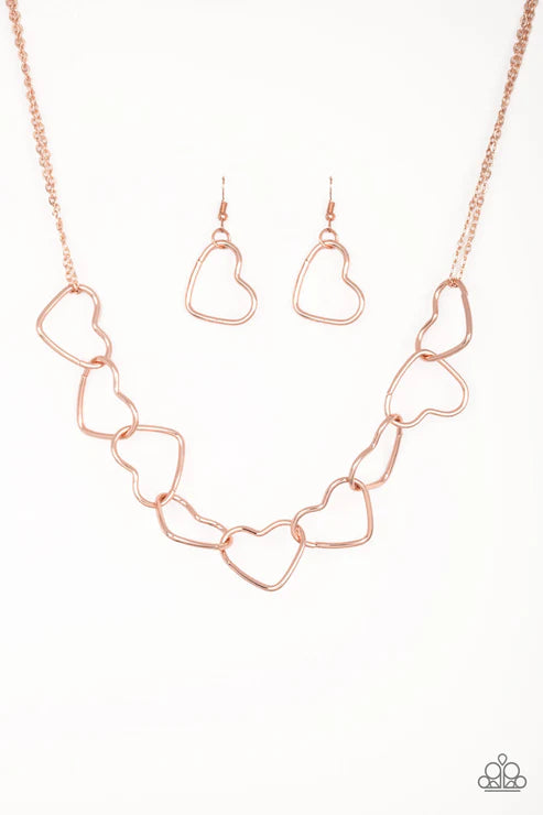 Rose gold heart-shaped necklace and earrings on a white background