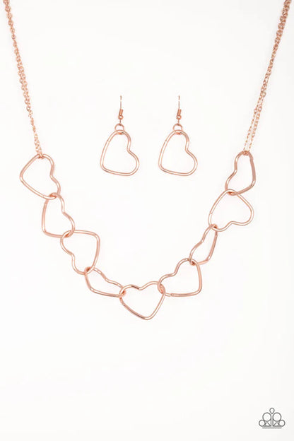 Rose gold heart-shaped necklace and earrings on a white background