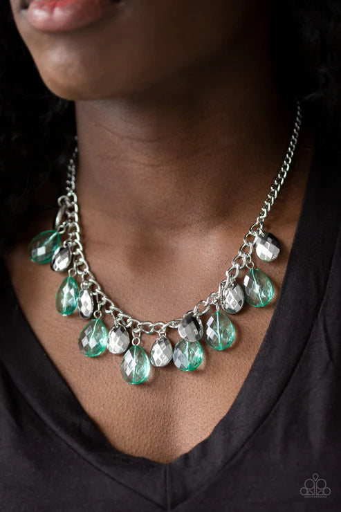 Necklace with green teardrop pendants worn by a person against a dark background