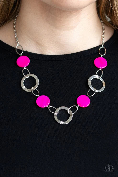 Necklace with pink beads and silver rings on a black background