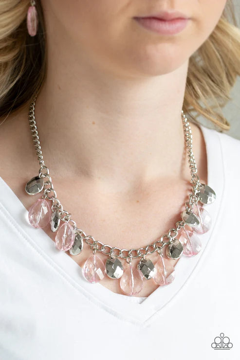 Necklace with pink beads and silver chain worn by a person