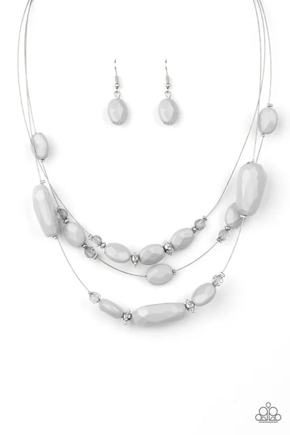 Necklace and earrings set with white beads on a white background
