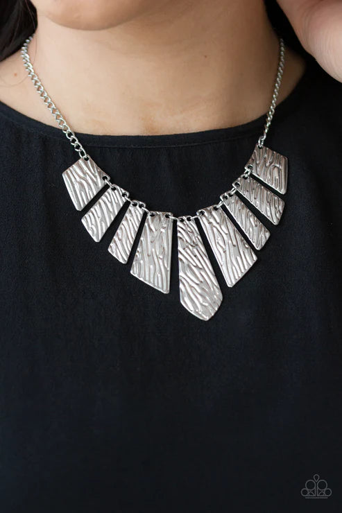Silver necklace with geometric pendants on a black background