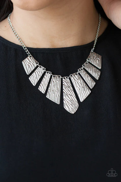 Silver necklace with geometric pendants on a black background