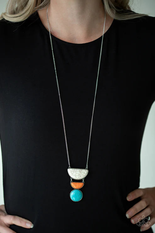 Long necklace with colorful pendant on a black shirt