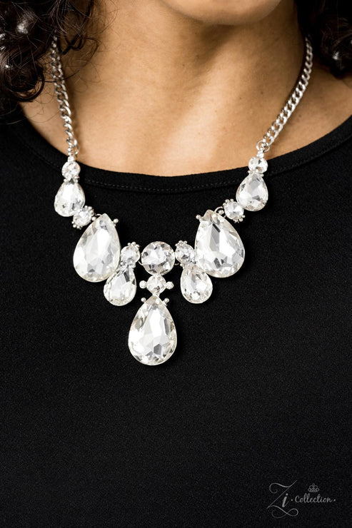 Close-up of a person wearing a sparkling necklace with teardrop-shaped crystals on a black background.