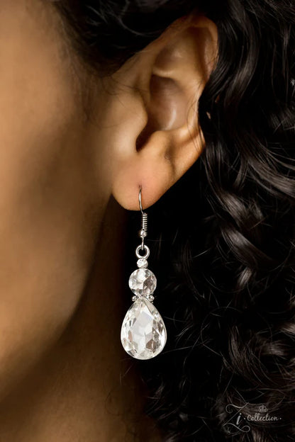 Close-up of an ear wearing a teardrop-shaped earring with a blurred background
