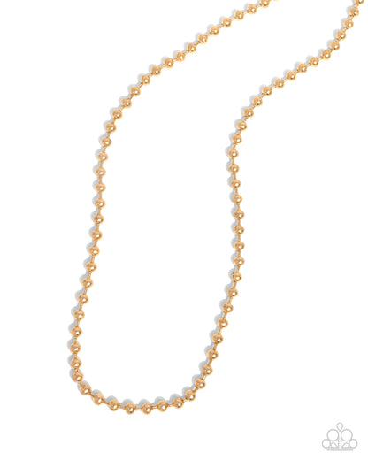 Gold beaded necklace on a white background