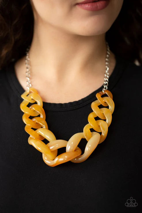 Yellow and beige chain necklace on a black background