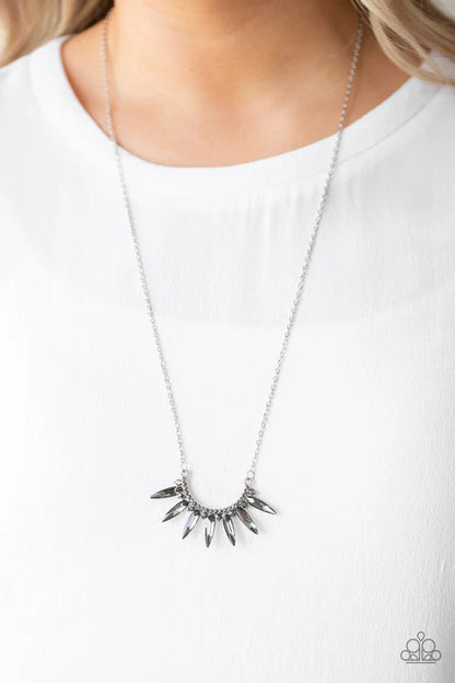 Silver necklace with spike-like ends on a white background