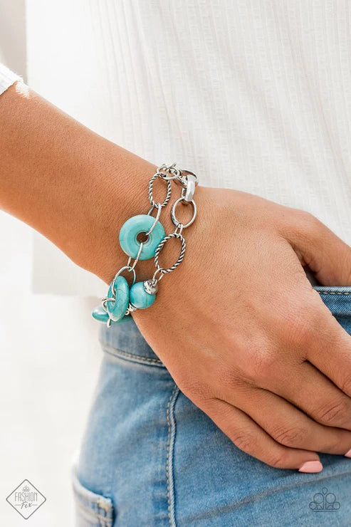 Turquoise bracelet with silver chain on a wrist against a white background
